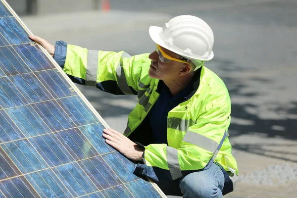 Engineer working on checking and maintenance equipment at solar panels power farm, photovoltaic cell park, green energy concept.