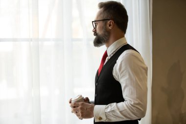 Sakallı hippi işadamı kahve fincanı portreleri tutuyor..