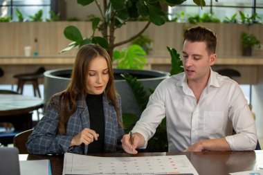 Genç iş adamları toplantı odasında istatistikleri tartışıyor ve inceliyor.