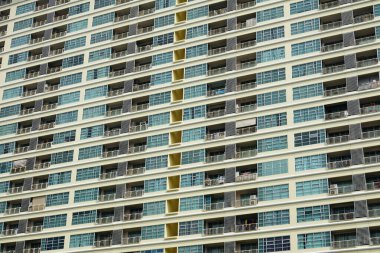 Renkli ön cepheli apartmanın alçak açısı ve sokakta metal parmaklıklar olan küçük balkonlar.