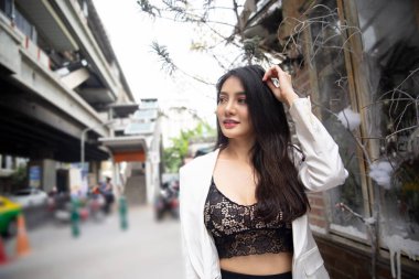 Soğuk kış sokağında duran beyaz ceketli güzel bir kadın.