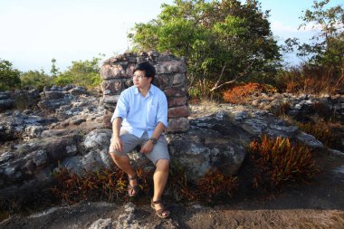 Taşın üzerinde oturan adam