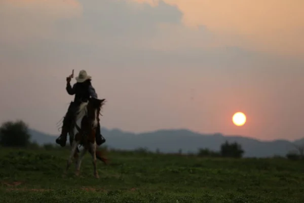 Kovboj Koni Rukou Drží Zbraň Proti Západu Slunce — Stock fotografie