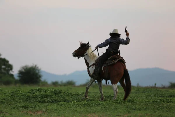 Cowboy Rijden Paard Met Hand Pistool Tegen Zonsondergang — Stockfoto