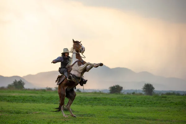 Cowboy Equitação Cavalo Com Mão Segurando Arma Contra Pôr Sol — Fotografia de Stock