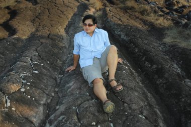 Taşın üzerinde oturan adam