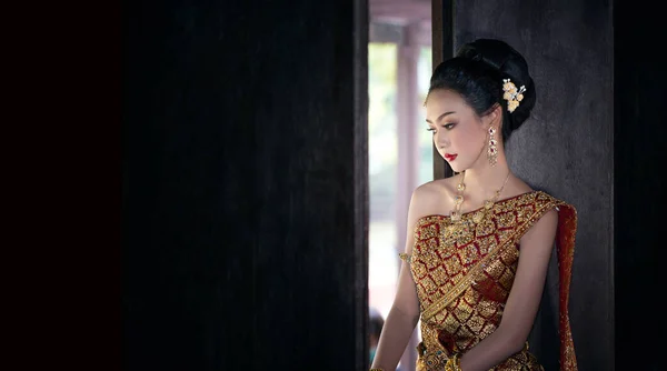 Uśmiechnięta Kobieta Tradycyjnej Odzieży Patrząc Daleko Stojąc Przeciwko Budynkowi — Zdjęcie stockowe
