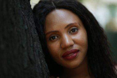 Ormanda ağaçların yanında duran neşeli genç kadın.. 