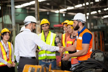 İşçi grubu, fabrikada işçi değişimi, insanlar endüstriyel bir girişim için kask ve üniforma giyerler.