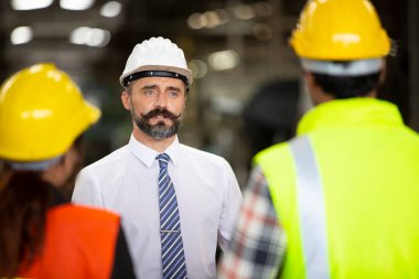İşçi grubu, fabrikada işçi değişimi, insanlar endüstriyel bir girişim için kask ve üniforma giyerler.
