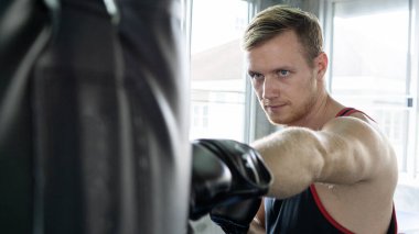 Spor salonunda boks çantalı genç boksör.