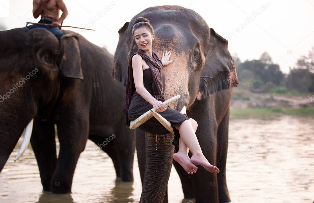 Portrait Of Smiling Woman Standing With Elephant In Thailand.