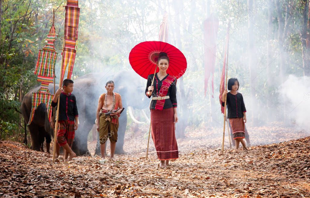 Portrait Of Smiling Woman with red umbrella Standing  In forest of Thailand.