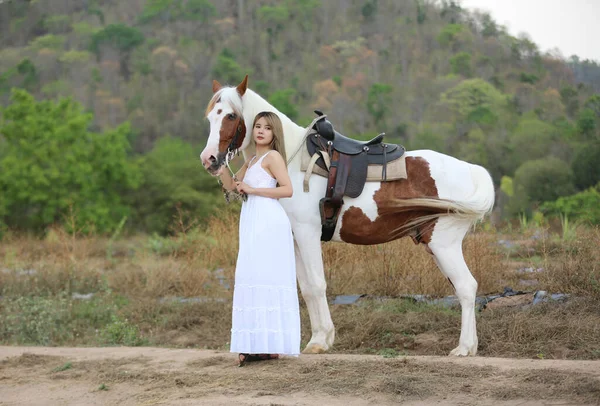 空に対する田園風景の中に女性乗馬馬の完全な長さ — ストック写真