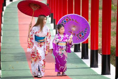  Kimonolu bir kadın Japon bahçesindeki tapınağa doğru yürüyor..