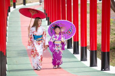  Kimonolu bir kadın Japon bahçesindeki tapınağa doğru yürüyor..