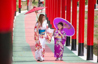  Kimonolu bir kadın Japon bahçesindeki tapınağa doğru yürüyor..