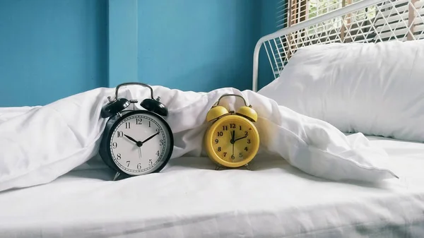 alarm clocks  on bed at home on blurred background