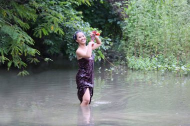 Nehirde Banyo Yapan Genç Asyalı Kadınlar ya da nehirde Banyo Yapan Güzel Asyalı Kadın Portresi. Asyalı seksi kadın derede yıkanıyor.. 