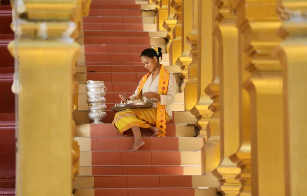 寺院で花を持つミャンマーの女性 東南アジアの若いです女の子とともに仏教寺院を訪れるビルマの伝統的なドレス — ストック写真