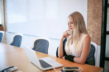 İş yerinde dizüstü bilgisayar kullanan gülümseyen bir kadın, izleyici çekmek ve içerik yaratmak isteyen küçük işletmeler için iş yerinde yeni pazarlama teknolojisi benimseyebilir. Serbest Çalışan Konsepti.