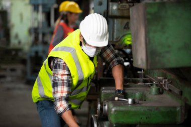 Mühendis müdürü ve Fabrika İşçi Takımı üretim hattında kontrol makinesi. Takım çalışması konsepti.