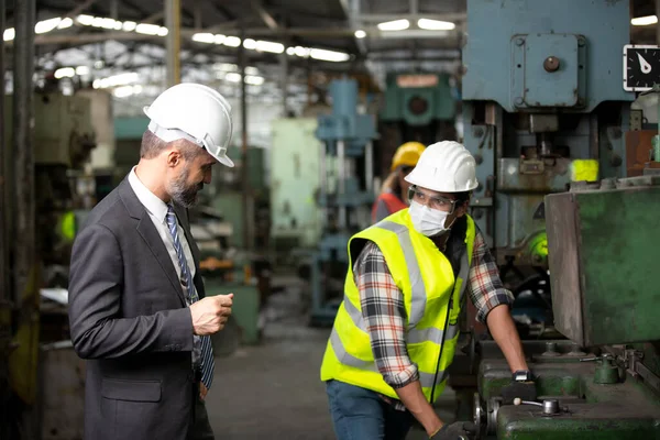 Engineer manager and Factory Workers Team checking machine in production line. Teamwork concept.