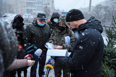 Ukrayna Devlet Ekolojik Teftişi 'nden müfettişler Noel ağacı satıcısıyla konuşuyor. Satış izni için belgelerini kontrol ediyorlar.