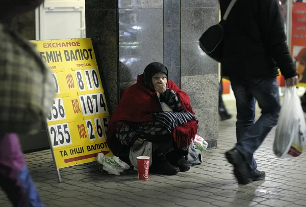 Uma velha mendigo de rua dando o dedo figo sentado perto de troca de moeda, pessoas passando por — Fotografia de Stock