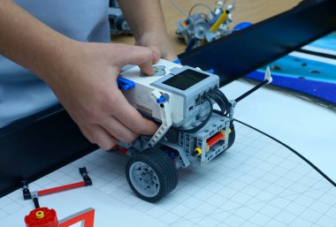 Erkek eller Lego bloklarından yapılmış robotları fırlatıyor.