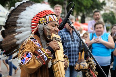 Perulu sokak müzisyeni, sokak müzisyeni, ulusal giysiler içinde, bir sokakta yerli rüzgar enstrümanı çalıyor. 9 Mayıs 2018. Kiev, Ukrayna