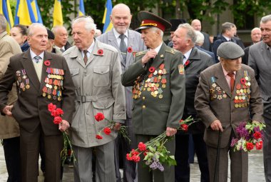 Gaziler Büyük Vatanseverlik Savaşı 'nın yaşlı bir adamı Zafer Günü' nde çiçeklerle ayakta duruyor. 9 Mayıs 2018. Kiev, Ukrayna