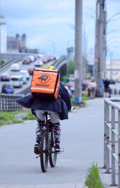 Hızlı teslimat servisi, kurye bisikleti şehrin caddesinde acele ediyor.