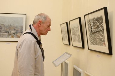 Ukraynalı ressam Mariia Diordichuk, Mariko Gelman 'ın Japon Yarıtonunda sergilediği resme bakan bir ziyaretçi. 12 Nisan 2018. Kyiv, Ukrayna