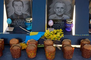 Kutsanmış Paskalya ekmekleri, 2013-14 devriminde öldürülen protestocuların portrelerinin yanına yerleştirildi. Cennetlik Yüz Kahramanlar Anıtı. 20 Nisan 2020. Kyiv, Ukrayna