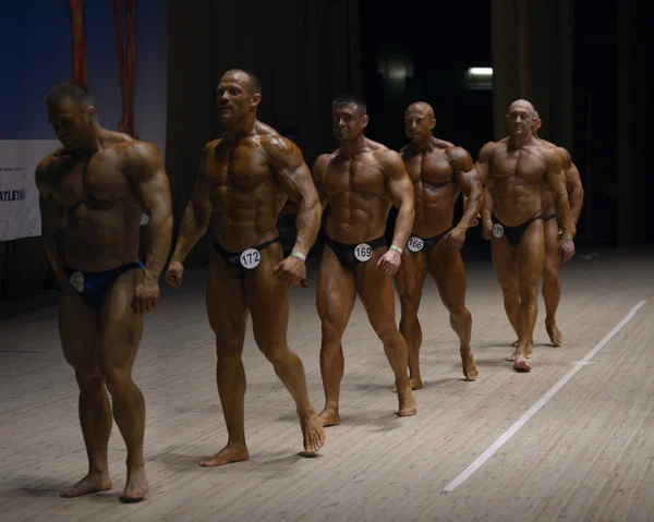 Manliga bodybuilders lämnar podiet. Ukraina bodybuilding och fitness cup. Kiev, 23 maj 2015. — Stockfoto