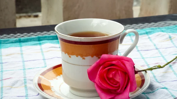 Çay tabağı üzerinde kırmızı gül çiçek