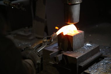 Isıtılmış malzemeleri çekiçle şekillendiren bir zanaatkar..