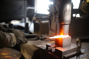 Isıtılmış malzemeleri çekiçle şekillendiren bir zanaatkar..