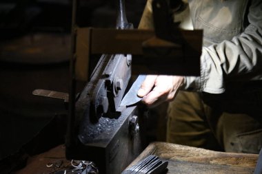 Bir zanaatkar, kumaşı bıçak şeklinde kesmek için el makasıyla keser.