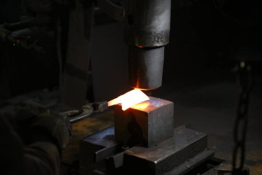 Isıtılmış malzemeleri çekiçle şekillendiren bir zanaatkar..