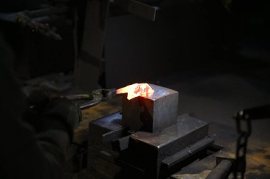 Isıtılmış malzemeleri çekiçle şekillendiren bir zanaatkar..