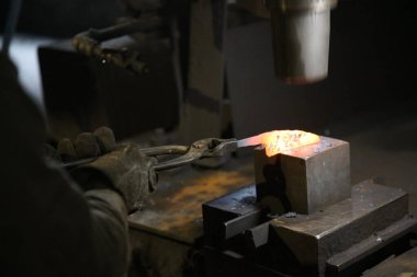 Isıtılmış malzemeleri çekiçle şekillendiren bir zanaatkar..