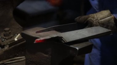 Isıtılmış malzemeleri çekiçle şekillendiren bir zanaatkar..