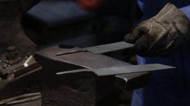 Isıtılmış malzemeleri çekiçle şekillendiren bir zanaatkar..