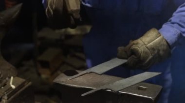 Isıtılmış malzemeleri çekiçle şekillendiren bir zanaatkar..