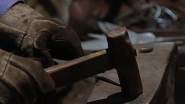 Isıtılmış malzemeleri çekiçle şekillendiren bir zanaatkar..