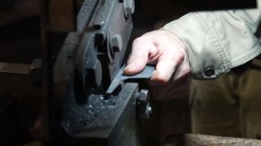 Bir zanaatkar, kumaşı bıçak şeklinde kesmek için el makasıyla keser.