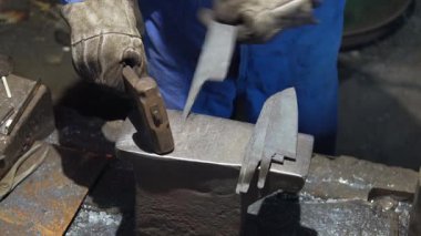 Isıtılmış malzemeleri çekiçle şekillendiren bir zanaatkar..