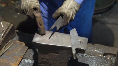 Isıtılmış malzemeleri çekiçle şekillendiren bir zanaatkar..